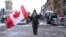 A protester stands in front of parked vehicles in downtown Ottawa, Ontario, February 3, 2022.