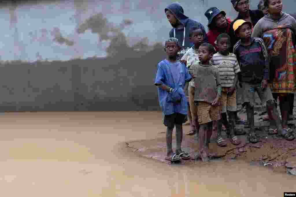 Locals stand next to a flooded area as Cyclone Batsirai sweeps inland in Fianarantsoa, Madagascar, Feb. 6, 2022. 