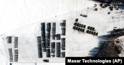 This satellite image shows troops and logistics material support units, near Yelsk, Belarus, Feb. 4, 2022. Russia has moved troops from Siberia and the Far East to Belarus for sweeping joint drills.