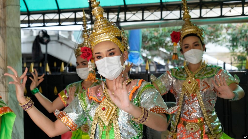 Thai classical dancers wearing face masks to help protect themselves from the coronavirus perform at the Erawan Shrine in Bangkok, Thailand, Monday, Feb. 7, 2022. (AP Photo/Sakchai Lalit)