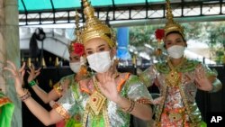 Thai classical dancers wearing face masks to help protect themselves from the coronavirus perform at the Erawan Shrine in Bangkok, Thailand, Monday, Feb. 7, 2022. (AP Photo/Sakchai Lalit)
