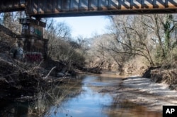 FILE - A portion of South Fork Peachtree Creek is shown on Wednesday, Jan. 26, 2022, in Decatur, Georgia. Jonathon Keats, an American conceptual artist, is in the process of devising a municipal clock to be located in Atlanta which would display time based on the flow rate of local rivers and waterways. (AP Photo/Ron Harris)