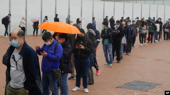 Residents line up to get tested for the coronavirus at a temporary testing center for COVID-19 in Hong Kong Monday, Feb. 7, 2022. (AP Photo/Vincent Yu)