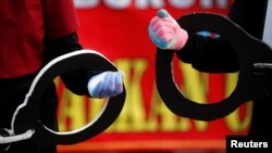 Anggota Serikat Pekerja Indonesia membawa borgol raksasa saat melakukan protes di Jakarta, 10 November 2020 sebagai ilustrasi. Kekerasan dapat terjadi di banyak tempat dan bisa melahirkan kekerasan lain. (Foto: REUTERS/Willy Kurniawan)