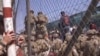 FILE - U.S. Marines are seen at Abbey Gate before a suicide bomber struck outside Hamid Karzai International Airport in Kabul, Afghanistan, Aug. 26, 2021, in this image from a video released by the Department of Defense.