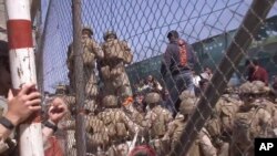 FILE - U.S. Marines are seen at Abbey Gate before a suicide bomber struck outside Hamid Karzai International Airport in Kabul, Afghanistan, Aug. 26, 2021, in this image from a video released by the Department of Defense.