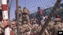 FILE - U.S. Marines are seen at Abbey Gate before a suicide bomber struck outside Hamid Karzai International Airport, in Kabul, Afghanistan, Aug. 26, 2021, in this image from a video released by the Department of Defense.