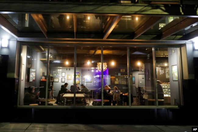 Customers gather at Cafe Cosmos in downtown Seattle, March 15, 2020, in Washington.