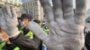 FILE - A policeman blocks the camera to stop journalists from recording footage outside the Shanghai Pudong New District People's Court, in Shanghai, Dec. 28, 2020.