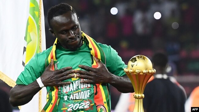 Senegal's forward Sadio Mane looks at the trophy prior to the ceremony after winning after the Africa Cup of Nations (CAN) 2021 final football match between Senegal and Egypt at Stade d'Olembe in Yaounde, Cameroon, on Feb. 6, 2022.