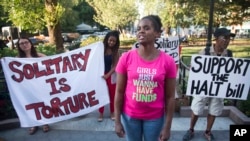 FILE - In this July 23, 2015 file photo, Candie Hailey, center, speaks during a monthly rally calling for the end of solitary confinement in New York. 