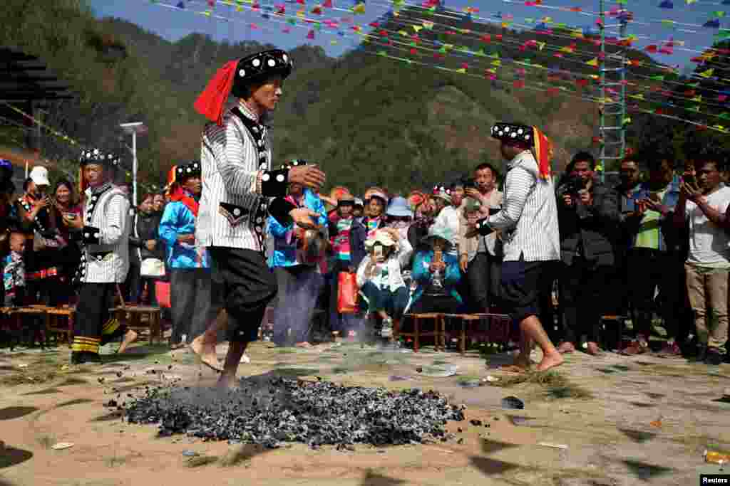 An ethnic Lisu man dances barefoot on hot charcoal embers to celebrate the annual Knife Pole Festival in Luzhang township of Nujiang Lisu Autonomous Prefecture in Yunnan province, China.