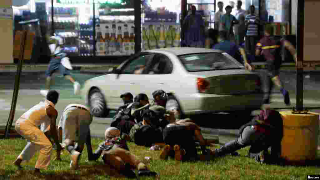 Des manifestants se cachent après avoir entendu des coups de feu, Ferguson, 9 août 2015. &nbsp;