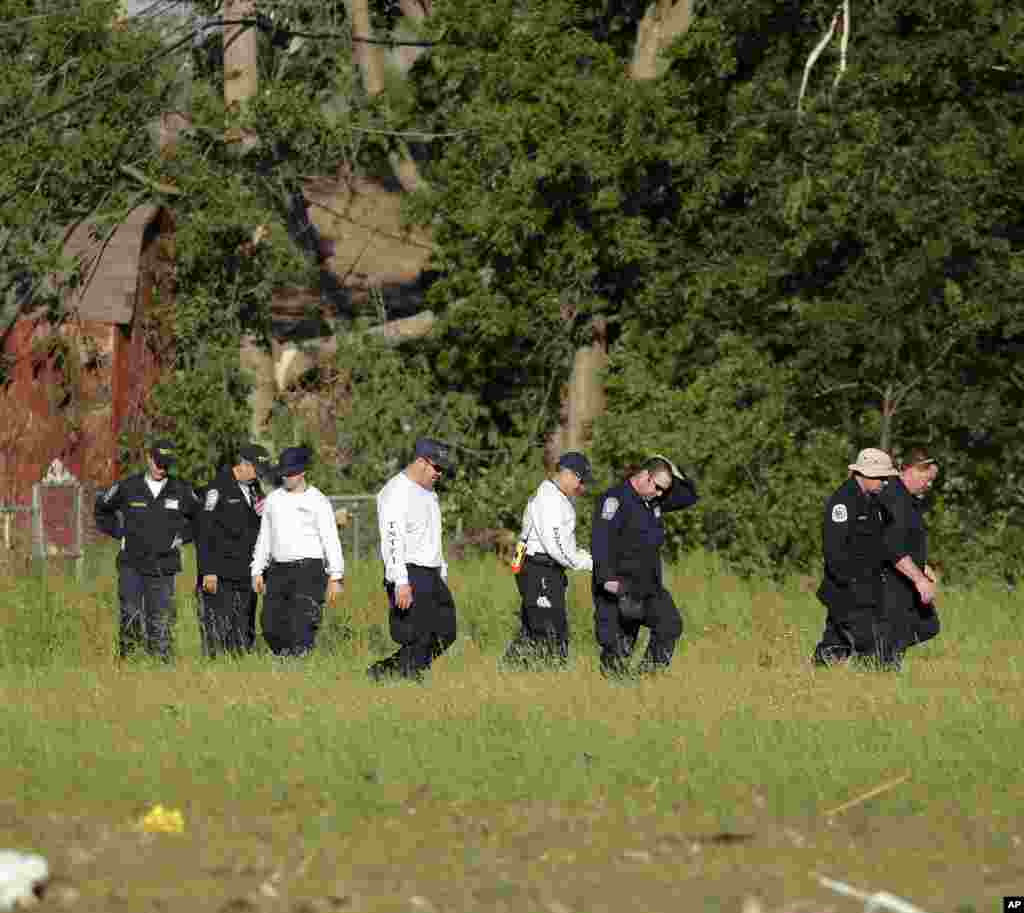 A search-and-rescue team from Tennessee searches a field, May 22, 2013, in Moore, Oklahoma. 