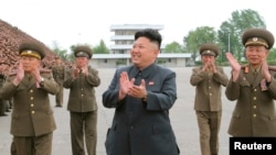 Pemimpin Korea Utara Kim Jong Un bertepuk tangan dalam sesi foto dengan tentara.