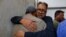 Relatives comfort each other at a hospital morgue as they mourn the death of a family member who was killed after a fire broke out at a multistory shopping mall in Karachi, Pakistan, on Nov. 25, 2023.