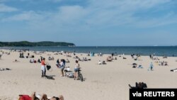 Personas disfrutan de la playa en el Mar Báltico luego del alivio de las restricciones por la COVID-19, en Sopot, Polonia, el 10 de mayo de 2020.