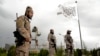 (FILE) Taliban special forces stand guard in front of the Taliban flag at a park in Kabul, Afghanistan, Monday, April 18, 2022.