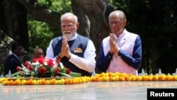 India's Prime Minister Narendra Modi, left, and his Mauritius counterpart Navin Ramgoolam pay homage after laying a wreath at the Sir Seewoosagur Ramgoolam Botanical Garden during his State visit, in Pamplemousses, Mauritius, March 11, 2025.