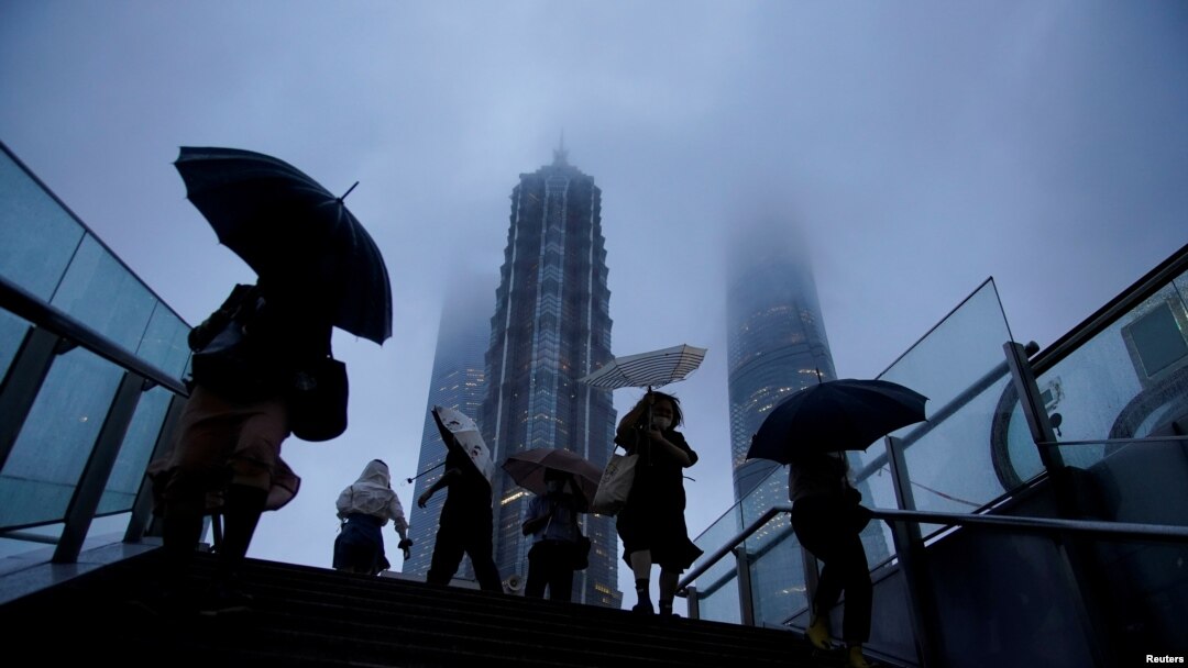 Warga membawa payung di tengah hujan saat Topan Chanthu mendekat, di Shanghai, China 13 September 2021. (REUTERS/Aly Song)