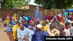 FILE - People wait to receive food donations from the United Nations World Food Program in Damasak, northeastern Nigeria, Oct. 6, 2024.