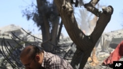 In this photo taken on a government-organized tour a local resident comfort reacts near ruins of destroyed building in the city of Surman, some 60 km west of Tripoli, Libya, on Monday, June 20, 2011.