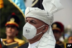 Afghan President Ashraf Ghani sings the national anthem at the Independence Minaret monument during the Independence Day celebrations at the Defense Ministry in Kabul, Afghanistan, Aug. 18, 2020.