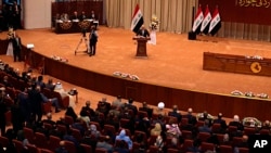 Iraq Prime Minister Haider al-Abadi, center, addresses a newly elected parliament during its first session in Baghdad, Sept. 3, 2018. 