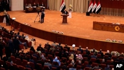 Iraq Prime Minister Haider al-Abadi, center, addresses a newly elected parliament during its first session in Baghdad, Sept. 3, 2018. 