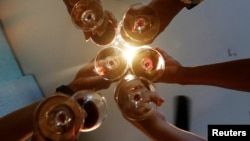 Men toast with their glasses of wine at a restaurant in Phnom Penh, Cambodia, October 18, 2018. 