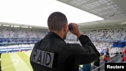 Polisi Perancis mengamati penonton di dalam stadion Bordeaux, tempat tim Belgia bertanding melawan Irlandia dalam kompetisi sepakbola Euro 2010 (18/6). (Reuters/Regis Duvignau)