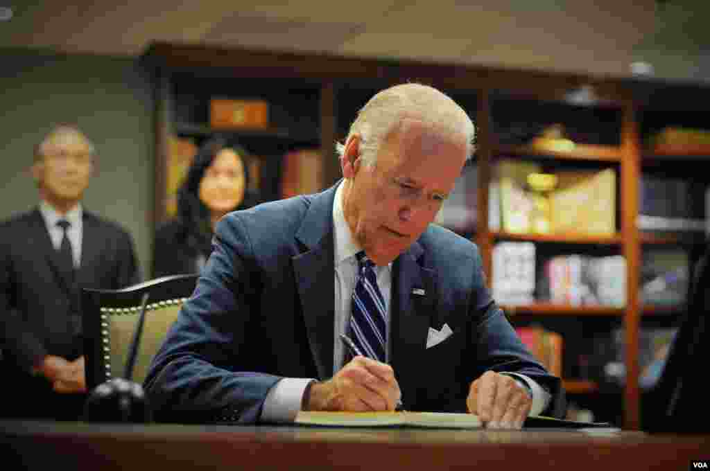 Vice President Joe Biden signs a book of condolences for His Majesty King Bhumibol Adulyadej