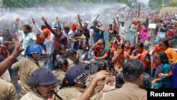 Bharatiya Janata Party supporters are sprayed with a water cannon as police try to stop them from reaching the office of Akhilesh Yadav, chief minister of Uttar Pradesh state, as they protest the recent rape and hanging of two girls, in Lucknow, India, June 2, 2014.