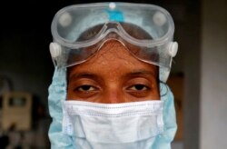 Petugas kesehatan yang mengenakan alat pelindung setelah dia mengambil sampel dari warga untuk tes antigen cepat, di tengah wabah COVID-19, di sebuah apartemen perumahan di Ahmedabad, India, 23 Juli 2020. (Foto: REUTERS/Amit Dave)