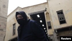 FILE - A woman wearing a protective face mask amid the COVID-19 outbreak walks at Al Khayamia street in old Islamic Cairo, Egypt, Sept. 5, 2021.