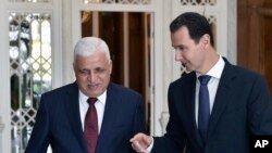 In this photo released by the Syrian official news agency SANA, Syrian President Bashar Assad, right, speaks with Iraq's National Security Adviser Faleh al-Fayadth, in Damascus, Syria, May. 18, 2017.