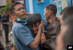 A man reacts after identifying his relative among the bodies of tsunami victims in Carita, Indonesia, Sunday, Dec. 23, 2018.