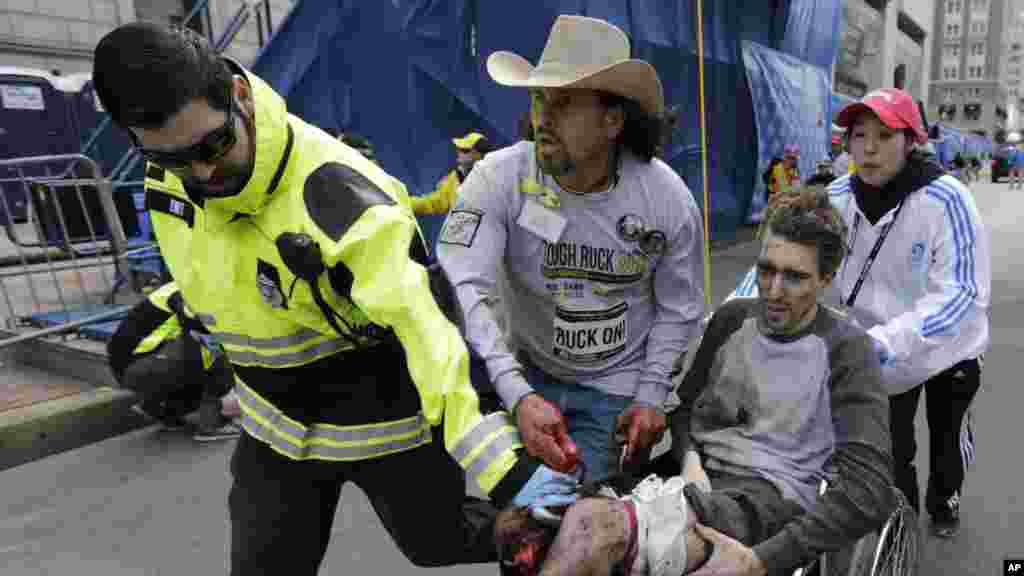 Medical responders run an injured man past the finish line the 2013 Boston Marathon following two explosions in Boston, April 15, 2013. 