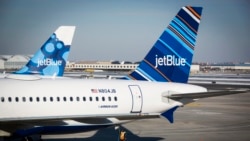 FILE - An airport worker fuels a JetBlue plane on the tarmac of the John F. Kennedy International Airport.