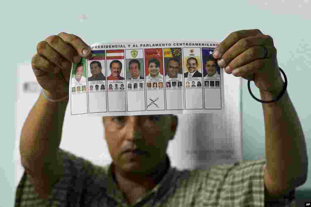 An election official shows a ballot marked for Free Party presidential candidate Xiomara Castro during the manual counting of votes after polls closed in Tegucigalpa, Honduras, Nov. 24, 2013. 