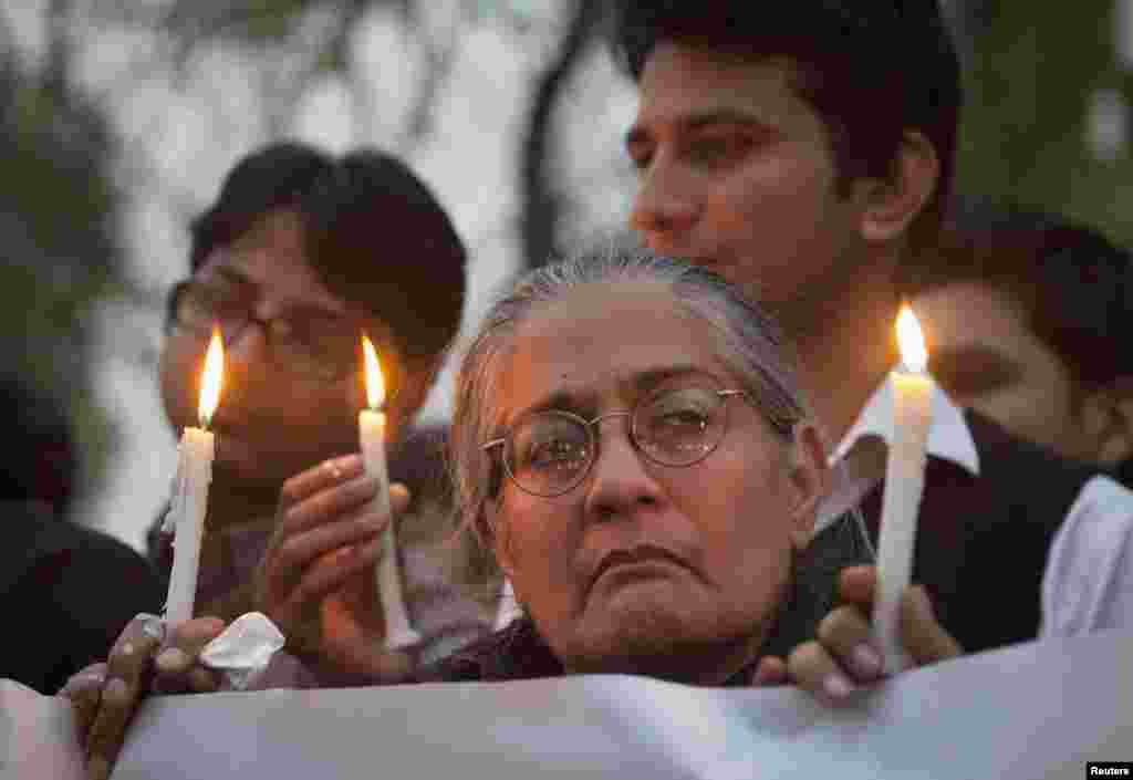 Members of various non-governmental organizations (NGOs) hold lighted candles during a protest in Islamabad against bomb blasts a day earlier in Quetta.