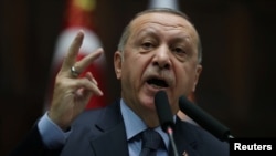 FILE - Turkish President Tayyip Erdogan addresses members of parliament from his ruling AK Party (AKP) during a meeting at the Turkish parliament in Ankara, Jan. 8, 2019. 