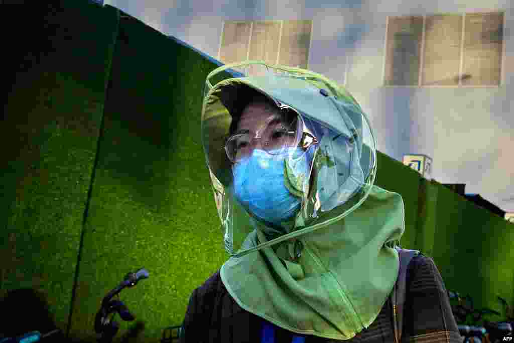 A woman wearing face coverings walks on a street in Beijing, China.