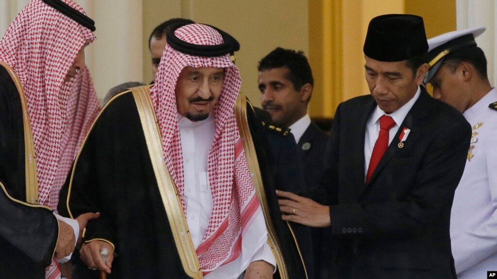 Presiden Joko Widodo membantu Raja Salman berjalan dalam pertemuan mereka di Istana Bogor (1/3). (AP/Achmad Ibrahim)