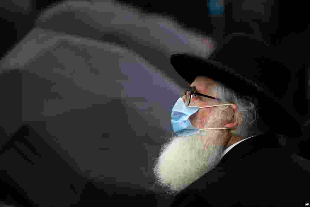 Rabbi Rafael Schaffer, wearing a mask for protection against the COVID-19 infection, stands outside the Holocaust memorial during the National Holocaust Remembrance Day commemorations in Bucharest, Romania, Friday, Oct. 9, 2020, the day when, in 1941, the