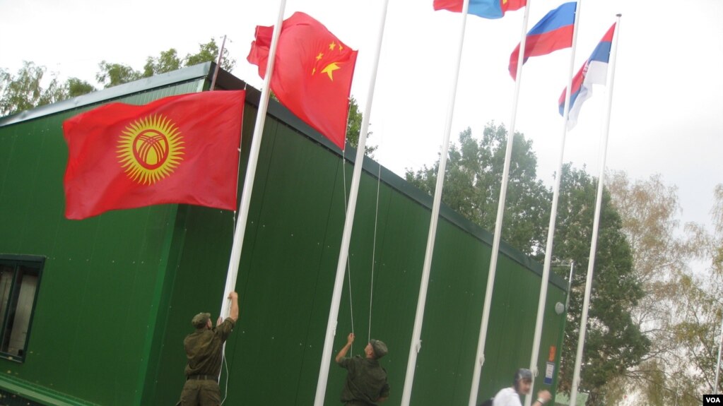 中亚国家经常与中国和俄罗斯共同参加一些活动。2014年在莫斯科郊外的军事比赛活动中，俄罗斯军人升中国和吉尔吉斯国旗。（美国之音白桦拍摄）(photo:VOA)