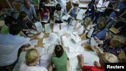Members of the election commission count ballot papers in a polling station in Kyiv, May 25, 2014.