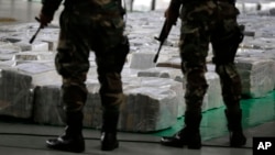FILE - Police officers stand guard over seized cocaine. 