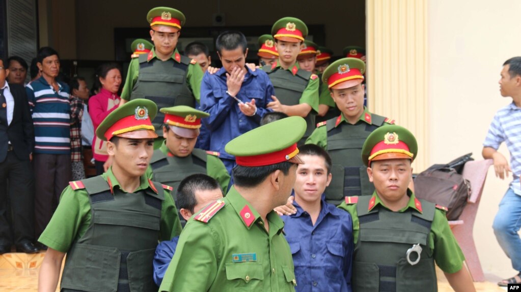 Công an áp giải những người biểu tình bị giam giữ khỏi tòa án ở tỉnh Binh Thuan, ngày 23 tháng 7, 2018, sau khi họ bị kết tội tham gia một vụ biểu tình bạo động chống luật đặc khu kinh tế vào tháng 6.