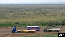 Trucks and buses drive past the area in Nairobi where Kenya's new Chinese-built rail line will cut through the capital's sprawling sanctuary for lions, giraffes and zebras, Aug. 4, 2015.